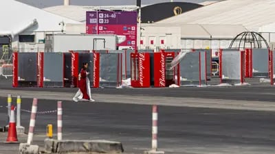 Workers walk past Budweiser coolers outside Lusail Stadium in Doha, Qatar, on Saturday, Nov. 19, 2022. The organizers behind the World Cup in Qatar have banned the sale of alcohol within stadium grounds.