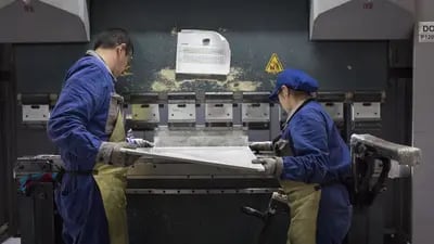 Empleados trabajan en piezas para un refrigerador en la línea de fabricación de electrodomésticos y muebles de cocina en la planta de producción de Challenger SAS en Bogotá, Colombia, el martes 20 de febrero de 2018.