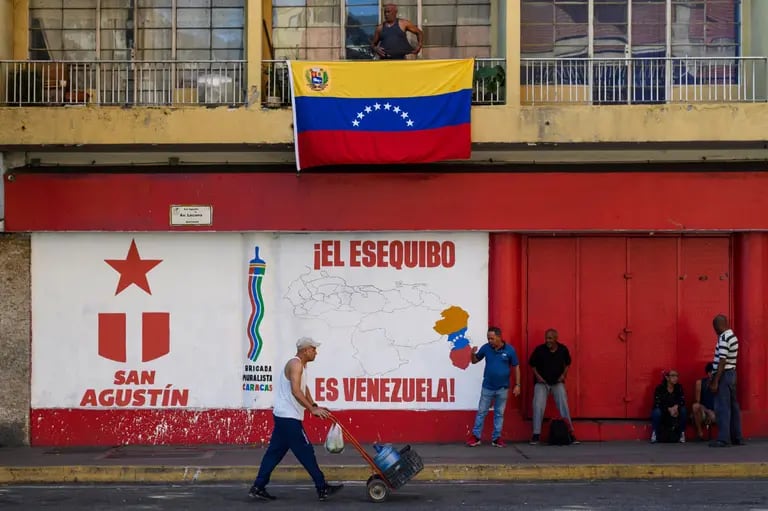 Peatones cerca de un mural que dice “El Esequibo es Venezuela”, durante un referéndum en Caracas, Venezuela, el domingo 3 de diciembre de 2023.Fotógrafo: Gaby Oraá/Bloombergdfd