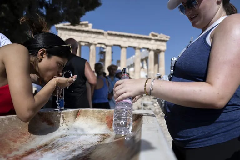 Turistas en una fuente de agua en el yacimiento arqueológico de la Acrópolis, durante condiciones climáticas de calor extremo, en Atenas en julio de 2023. dfd