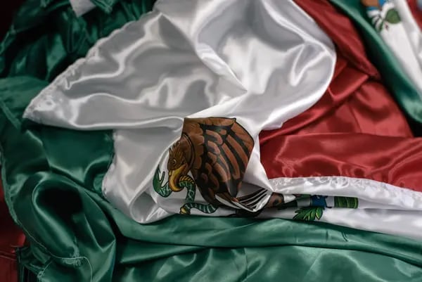 A Mexican national flag lies folded on a table in Toluca, Mexico. Photographer: Luis Antonio Rojas/Bloomberg