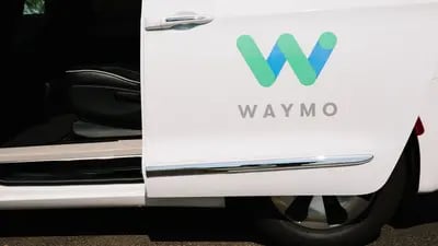 Señalización de Waymo LLC se muestra en la puerta abierta de un vehículo autónomo Chrysler Pacifica en Chandler, Arizona, Estados Unidos, el lunes 30 de julio de 2018.