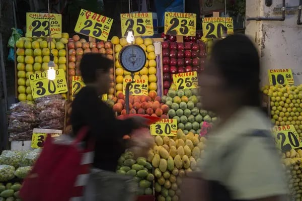 Shoppers walk past a fruit stand at the Central de Abasto market in the Iztapalapa neighborhood of Mexico City, Mexico, on Tuesday, July 28, 2015. Just as Mexico's consumer sector begins to emerge from the doldrums of the 2009 recession, a new government report suggests the recovery's foundation is on shaky ground. Photographer: Susana Gonzalez/Bloomberg