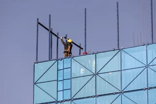 Un trabajador instala elementos de seguridad en una construcción