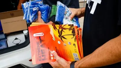 Una representante del Fideicomiso para los Sin Techo del condado de Miami-Dade distribuye información sobre refugios durante una ola de calor en Miami, en julio de 2023.
