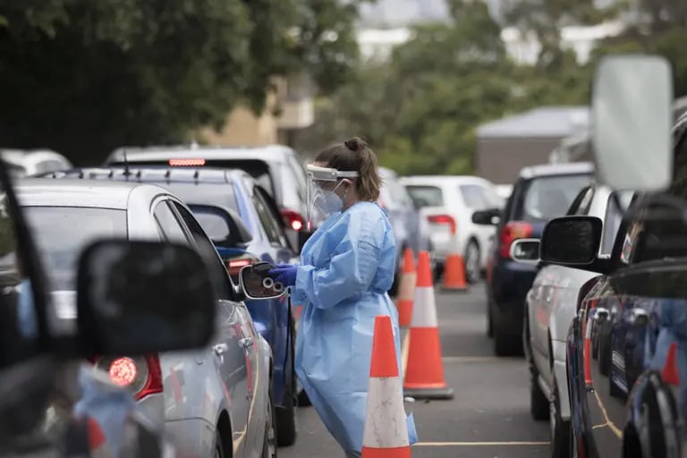 Profissional de saúde atende pessoa dentro de um carro para testagem de Covid-19 na cidade de Sydneydfd