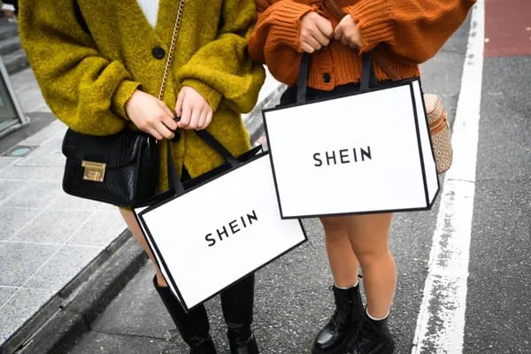 Clientes sostienen bolsos Shein en el exterior de la sala de exposiciones Shein Tokio en Tokio, Japón.