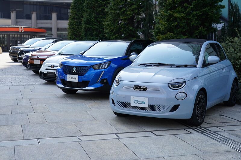 A Fiat 500e electric automobile, from right, a Peugeot e-2008 electric sports utility vehicle (SUV), an Abarth 595 Competizione vehicle, a Citroen e-C4 electric vehicle, an Alfa Romeo Giulia sedan, a Citroen DS7 Crossback sports utility vehicle (SUV) and a Jeep Grand Cherokee L vehicle, displayed outside the Stellantis Japan Ltd. office in Tokyo, Japan, on Tuesday, March 1, 2022. Stellantis Japan officially kicked off Tuesday, merging eight brands under one umbrella. The company plans to roll out 19 electric cars this year. Photographer: Toru Hanai/Bloomberg
