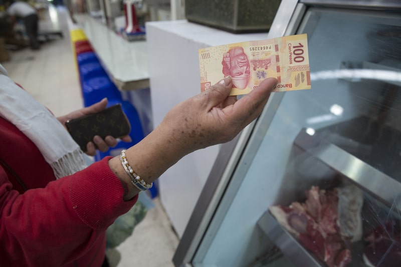 Un cliente cambia pesos mexicanos por mercancías en el mercado de Medellín, en Ciudad de México.