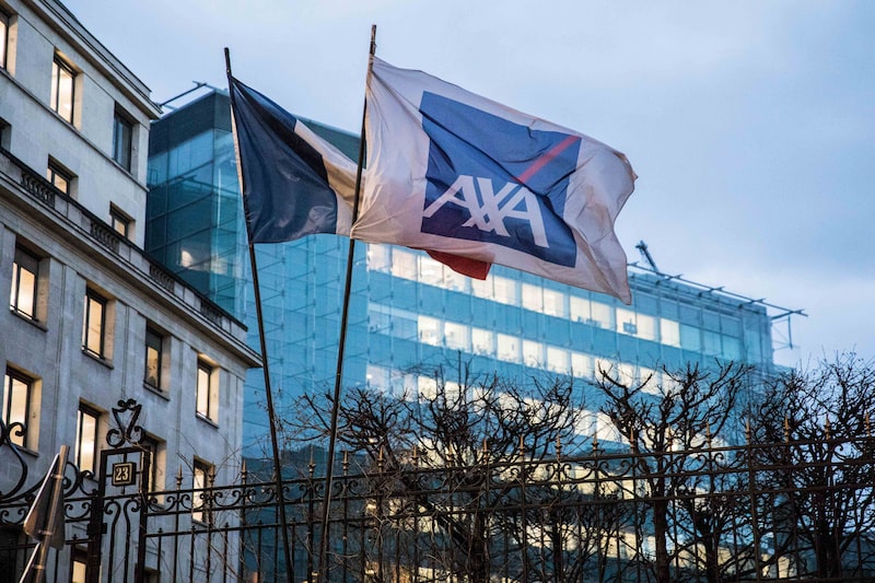 A French national flag and a flag displaying the AXA SA logo fly outside the insurance company's headquarters in Paris, France, on Tuesday, March 6, 2018. Axa Chief Executive Officer Thomas Buberl’s $15.3 billion purchase of XL Group Ltd., the company’s biggest ever, will make Axa the top provider of commercial casualty coverage just as premiums rise after last year’s hurricanes and California wildfires. Photographer: Christophe Morin/Bloomberg