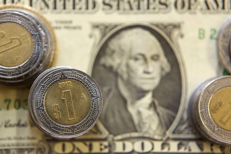 A U.S. one dollar bill and Mexican pesos coins are arranged for a photograph inside a currency exchange center in Mexico City, Mexico, on Tuesday, July 9, 2013. Mexicos peso rose for the first time in three days on July 11 after Federal Reserve Chairman Ben S. Bernanke called for maintaining a U.S. stimulus program that has boosted demand for the Latin American countrys securities. Photographer: Susana Gonzalez/Bloomberg