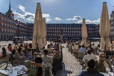 Customers dine at outside tables of a restaurant terrace in Plaza Mayor square, Madrid, Spain, on Saturday, April 17, 2021. European travel and leisure stocks have gained 20% this year on the expectation that an accelerating vaccine rollout will pave the way for normal travel patterns after a yearlong slump in air traffic and hotel-stays induced by the pandemic. Photographer: Paul Hanna/Bloomberg