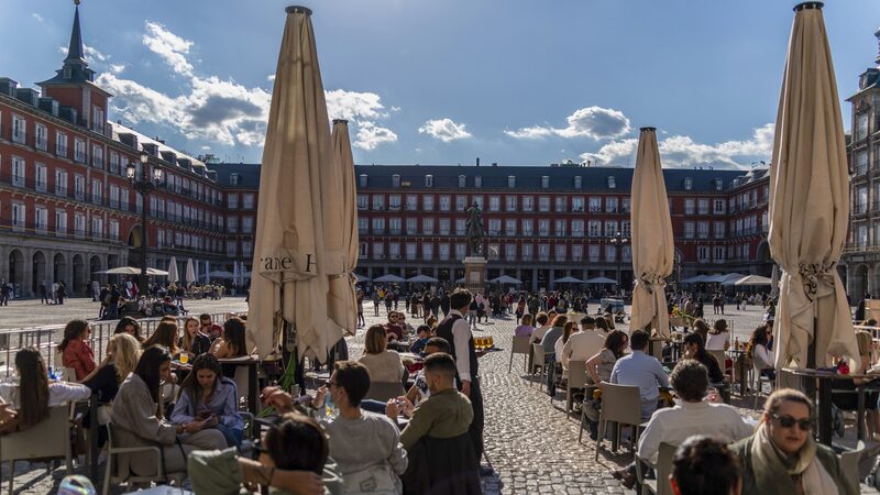 Customers dine at outside tables of a restaurant terrace in Plaza Mayor square, Madrid, Spain, on Saturday, April 17, 2021. European travel and leisure stocks have gained 20% this year on the expectation that an accelerating vaccine rollout will pave the way for normal travel patterns after a yearlong slump in air traffic and hotel-stays induced by the pandemic. Photographer: Paul Hanna/Bloomberg