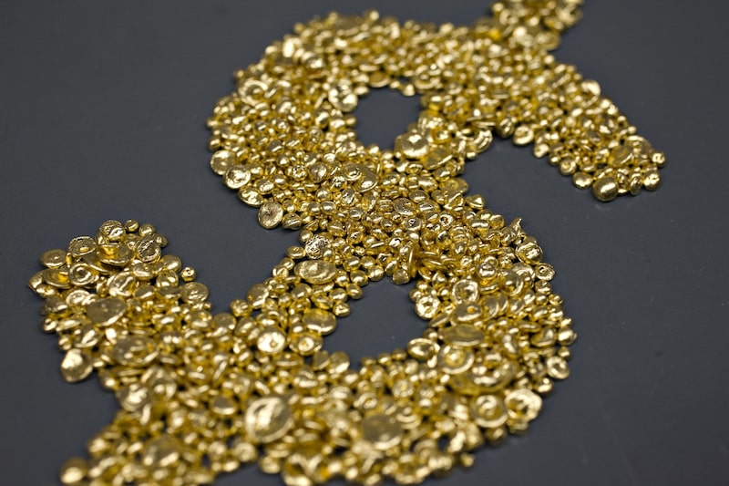 Granos de fundición de oro puro dispuestos en forma de signo del dólar en la refinería Dvir & Stoler.