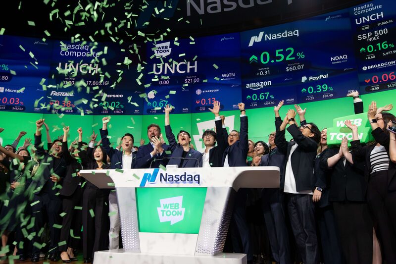 Junkoo Kim, chief executive officer of Webtoon Entertainment Inc., center, rings the opening bell during the company's initial public offering at the Nasdaq MarketSite in New York, US, on Thursday, June 27, 2024. Online comics company Webtoon Entertainment Inc. priced shares in its US initial public offering at the top of a marketed range to raise $315 million after backer Naver Corp. this year accelerated plans for its market debut. Photographer: Michael Nagle/Bloomberg