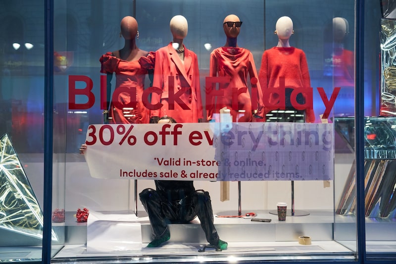 Foto de uma vitrine de loja com quatro manequins vestindo roupas vermelhas